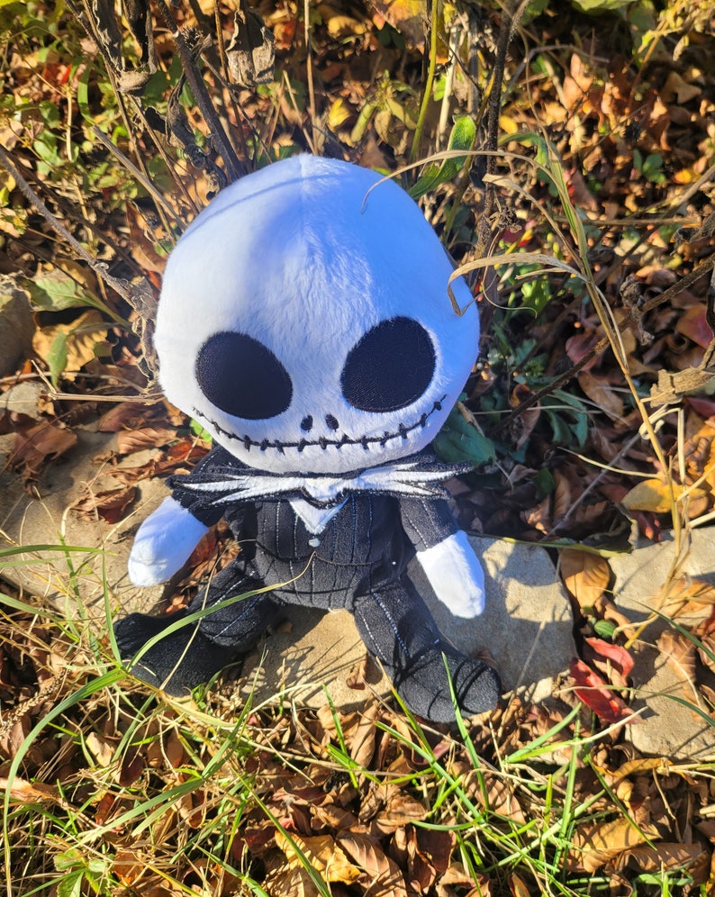 Op de afbeelding: Een pluche speelgoed van Jack Skellington uit de film Nightmare Before Christmas. Het speelgoed draagt een zwart-wit gestreept pak en heeft een wit gezicht met zwarte ogen en een gestikte mond.
