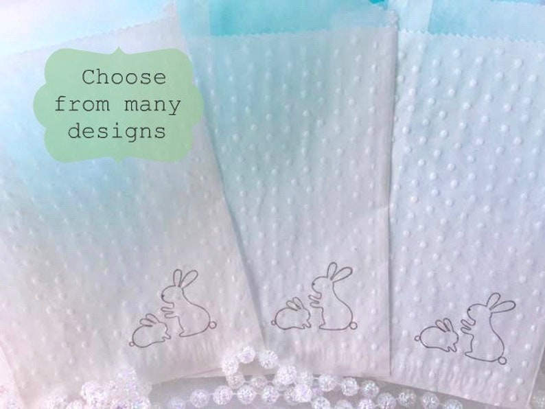 May include: White paper gift bags with a dotted texture and a line drawing of a mother and baby bunny. The bags have a light blue and white gradient background. Text on the image says "Choose from many designs".