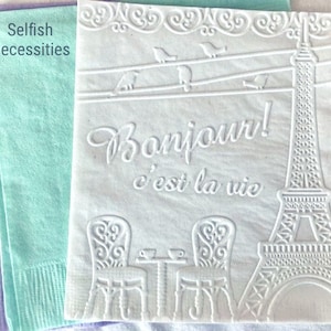 White, lavender and mint cocktail napkins are embossed with a French cafe scene to give texture. The Eiffel Tower is displayed along with a cafe table and chairs and the word Bonjour!