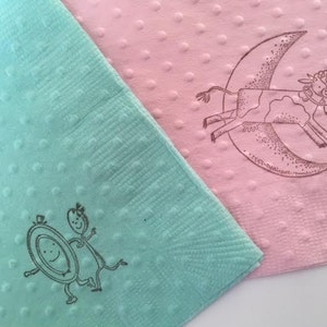 Mint and pink napkins with polka dots with nursery rhyme image stamped onto them. The images show the dish ran away with the spoon and the cow jumped over the moon.