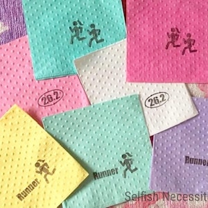 May include: Assortment of colorful napkins with a running figure and the text "Runner" and "26.2" printed on them. The napkins are decorated with small dots.
