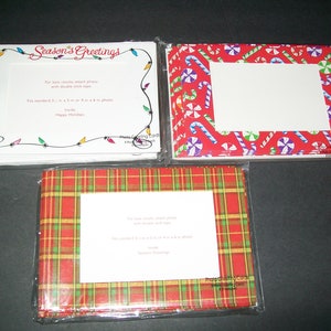 May include: Three packs of Christmas photo greeting cards. The first pack has a white background with a black outline of a string of Christmas lights. The second pack has a red background with a pattern of candy canes and peppermint swirls. The third pack has a red and green plaid pattern.