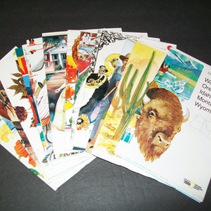 May include: A stack of vintage travel brochures featuring colorful illustrations of various American states, including a close-up of a bison, a cactus, and a mountain range. The cover of the brochure reads "Close-Up: U.S.A. Washington, Oregon, Idaho, Montana, Wyoming".