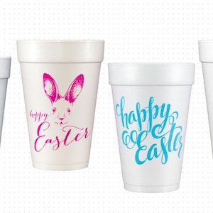 May include: Four white foam cups with Easter-themed designs. One cup has pink bunny ears and the words "Happy Easter." Another features a pink bunny face and the words "Happy Easter." The third cup says "Happy Easter" in blue script. The last cup says "Chillin with my Peeps."