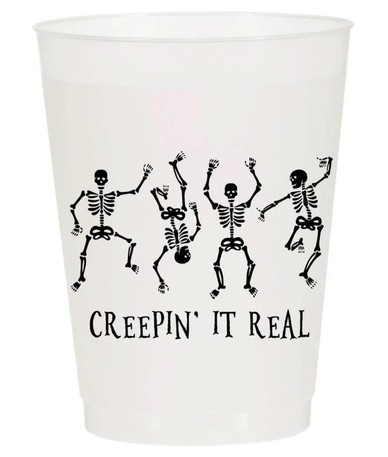May include: A white plastic cup with a black graphic of dancing skeletons. The phrase "CREEPIN' IT REAL" is printed in black below the skeletons. Ideal for Halloween or spooky-themed parties.