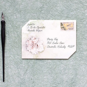 Pode incluir: Um envelope branco com uma ilustra&ccedil;&atilde;o de aquarela de uma flor. O envelope &eacute; endere&ccedil;ado a Daisy Fay na 502 Linden Lane, Louisville, Kentucky 40214.
