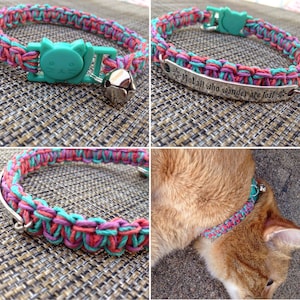 Puede incluir: Un collar para gato trenzado de color rosa, verde azulado y rojo con una campanilla y una etiqueta plateada que dice "Not all who wander are lost".