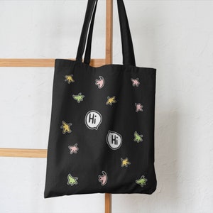 Heartstopper Leaves Tote Bag in Black with FREE Vinyl Stickers. Heartstopper leaves printed on both sides of the bag along with two Hi quotes from the show.