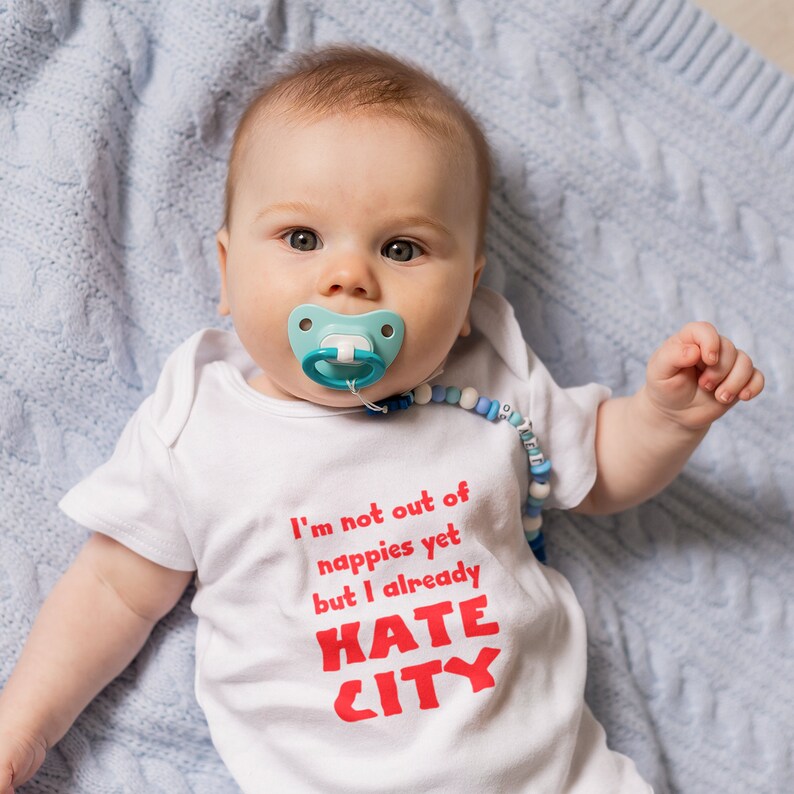 Manchester United Baby Gift. Hate City Baby Grow.  Baby with Pacifier.