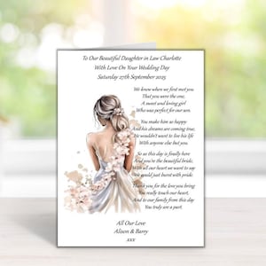 Puede incluir: Tarjeta de boda con una ilustraci&oacute;n en acuarela de una novia con un vestido blanco, con detalles florales. La tarjeta incluye el texto "To Our Beautiful Daughter in Law Charlotte" y un mensaje conmovedor.