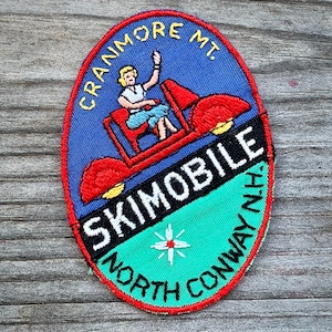 May include: A blue and green embroidered patch with a red and white cartoon car and the text "Cranmore Mt. Skimobile North Conway, NH."