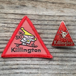 May include: Red triangular patch with a cartoon skier and the text "Killington" in black. A smaller red triangular pin with the text "Killington" in white is also shown.
