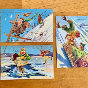 May include: Three vintage postcards featuring winter sports scenes. The first postcard shows a skier on a snowy slope with the text "We Are Not Experts- But We're Havin' Lotsa Fun!" The second postcard shows a person ice fishing with the text "If I Don't Get a Line From You - I'm Sunk." The third postcard shows a group of people sledding with the text "Traveling in Fast Company."