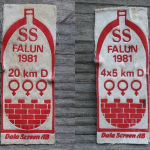 May include: Two white fabric patches with red text and graphics. The text reads "SS FALUN 1981" and "Dala Screen AB". One patch says "20 km D" and the other says "4x5 km D". Both patches have three female symbols.