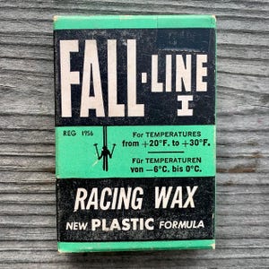 May include: A green and black box with the text "FALL-LINE" in white letters. The box also has the text "RACING WAX" in white letters and "NEW PLASTIC FORMULA" in white letters. The box has the text "REG 1956" in white letters. The box also has the text "For TEMPERATURES from +20°F. to +30°F." and "Für TEMPERATUREN von -6°C. bis 0°C."