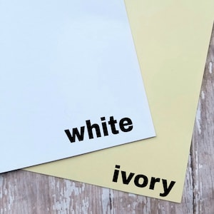 May include: Two sheets of paper, one white and one ivory, are displayed. The word "white" is printed in bold, black letters on the white sheet. The word "ivory" is printed in bold, black letters on the ivory sheet.