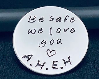 May include: Silver round charm with the text "Be safe we love you" and a heart symbol. The initials "A.H.E.H." are engraved below the text.