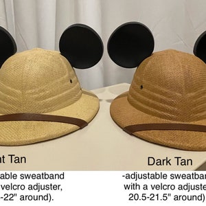 May include: Two safari hats with Mickey Mouse ears. The hat on the left is light tan and the hat on the right is dark tan. Both hats have adjustable sweatbands with velcro adjusters. The light tan hat is 20.5-22 inches around and the dark tan hat is 20.5-21.5 inches around.