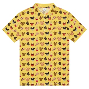 May include: Yellow polo shirt featuring a repeating pattern of Mickey Mouse-themed treats, such as ice cream bars, pretzels, and pizza slices. The shirt has a collared neckline and short sleeves.