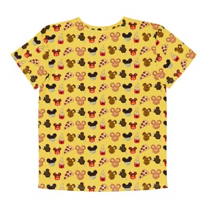 May include: Yellow t-shirt featuring a repeating pattern of cartoon food. The design includes Mickey Mouse-shaped ice cream, pretzels, pizza slices, and ice cream cones. The shirt is made of a soft, comfortable material.