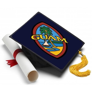 May include: A graduation cap with a Guam flag design, featuring a palm tree, sailboat, and the word "GUAM" in yellow. A rolled-up diploma tied with a red ribbon and a gold tassel complete the graduation theme.