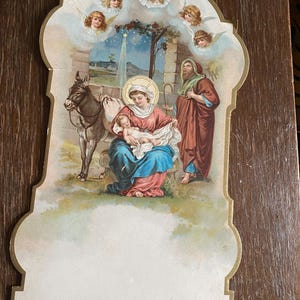Tarjeta navideña antigua de cartón duro victoriana francesa con escena de nieve invernal, niña junto a una cerca, arbusto de bayas sagradas en la nieve, calendario antiguo recortado en la parte superior