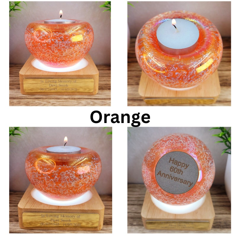 May include: Orange glass candle holder with a lit tealight candle. The candle holder sits on a wooden base with a white light. The text "In Loving Memory of Dave Smith" is engraved on the base. The word "Orange" is also visible.