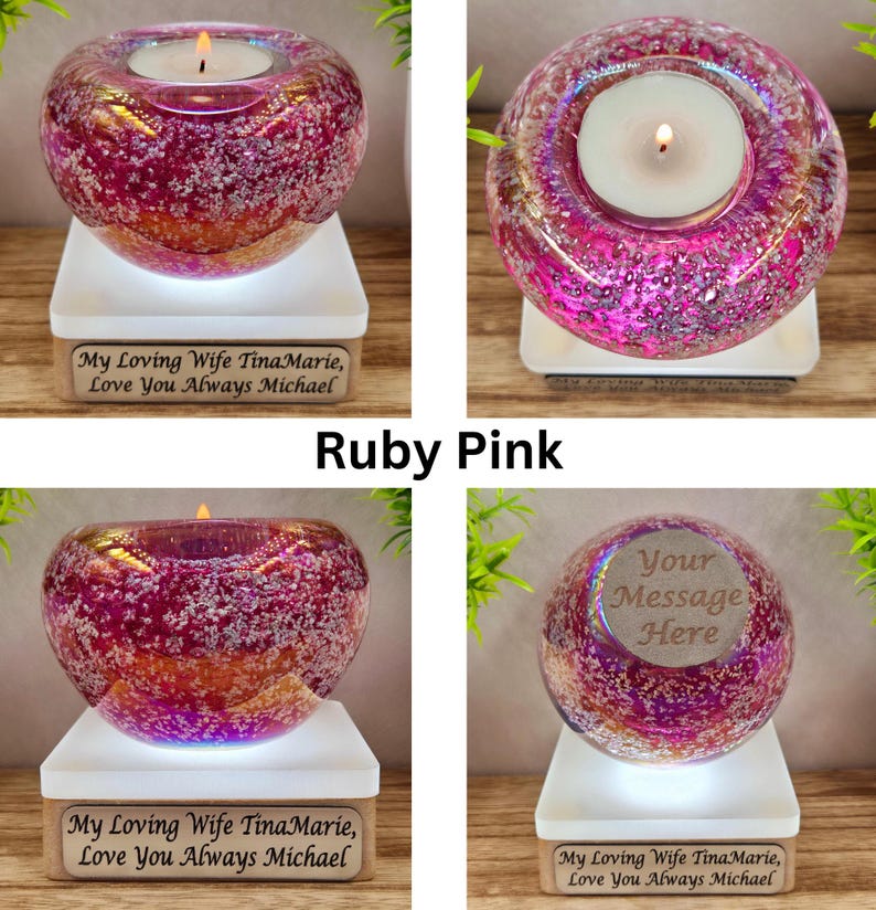 May include: Ruby pink glass candle holder with a lit candle, set on a white base. The base has text that reads "My Loving Wife TinaMarie, Love You Always Michael". The candle holder is a decorative item.