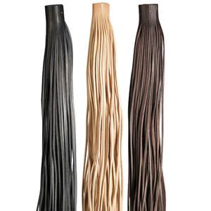 Könnte beinhalten: Drei Lederkordeln in verschiedenen Farben: Schwarz, Beige und Braun. Die Kordeln sind gebündelt und hängen herunter.