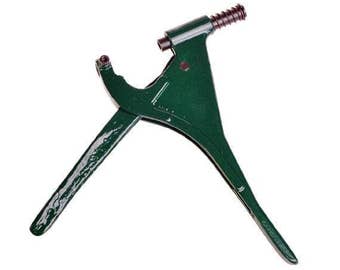 May include: Green metal hand-operated tool with a long handle and a smaller handle with a threaded knob. The tool is used for setting eyelets.