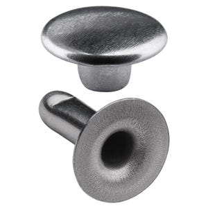 May include: Silver metal rivet with a round head and a hollow base. The rivet is separated into two parts, the head and the base.
