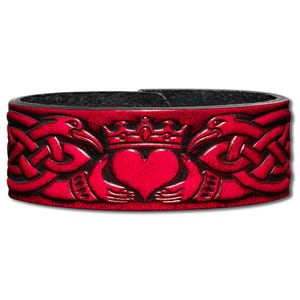 Könnte beinhalten: Rotes Lederarmband mit einem keltischen Knotendesign und einer Krone über einem von zwei Händen umschlossenen Herzen.