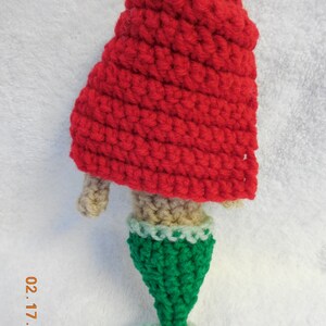 May include: A crocheted mermaid doll with a red hooded top and a green tail.
