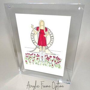 May include: A framed illustration of a woman in a red dress standing in front of the Texas Tech University seal. The woman is holding up two fingers in a peace sign. The seal is surrounded by red tulips.