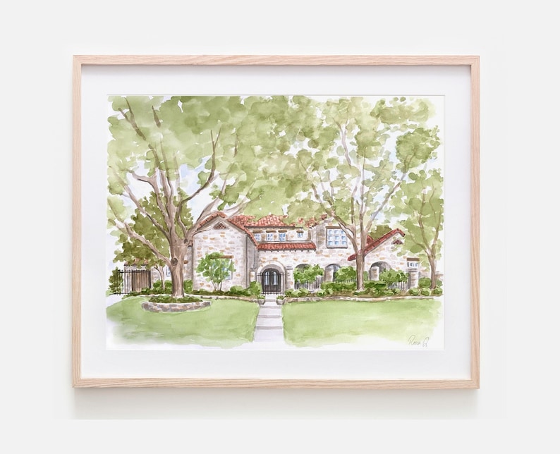 May include: A watercolor painting of a stone house with a red tile roof, arched entryway, and large green trees in a light wood frame. The artwork depicts a front lawn, a stone walkway, and a signature in the bottom right corner of the paper.