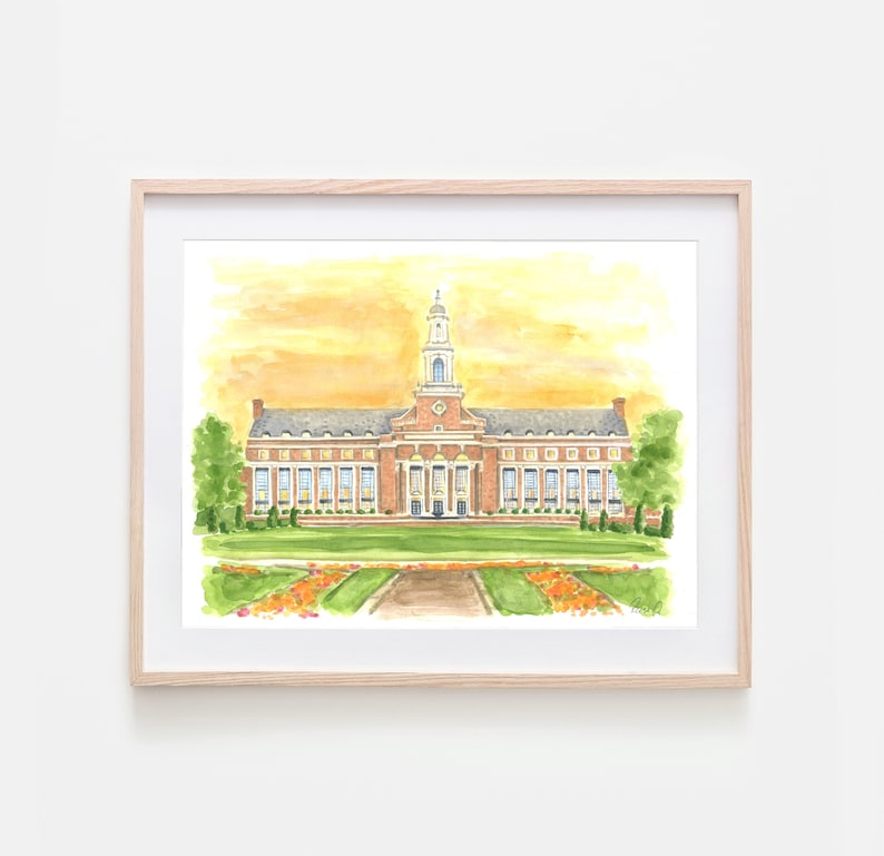 Pode incluir: Uma pintura em aguarela de um edif&iacute;cio de tijolo com uma torre central e colunas brancas, contra um c&eacute;u amarelo. A cena inclui um relvado verde, canteiros de flores cor de laranja e &aacute;rvores, numa moldura de madeira clara.