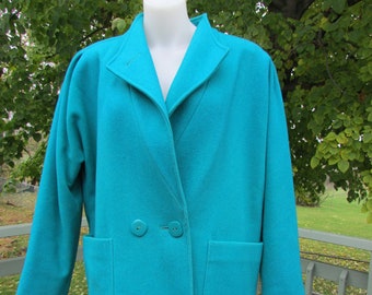 May include: A turquoise blue wool coat with a collar, two pockets, and a double breasted closure with two buttons.