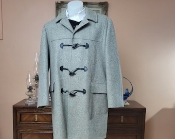 May include: A gray wool toggle coat with black toggles and a black lining. The coat has a classic design and is perfect for cold weather.