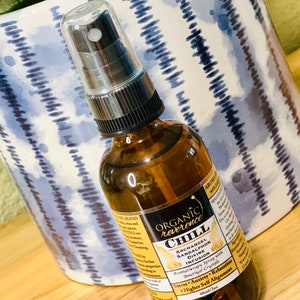 Może przedstawiać: Brązowa szklana butelka z czarną dyszą rozpylającą i białą etykietą z napisem "ORGANIC reverence CHILL ARCHANGEL SANDALPHON DIVINE INFUSION Aromatherapy Spray with Amethyst Crystals Stress Anxiety Relaxation Higher Self Alignment 60ml/2oz"