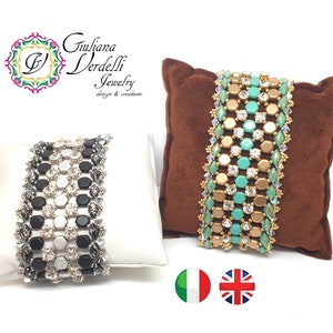 Può includere: Due braccialetti di perline in mostra. Un braccialetto è nero, bianco e argento. L'altro braccialetto è oro, turchese e trasparente. Entrambi i braccialetti sono su cuscini di velluto marrone e bianco.