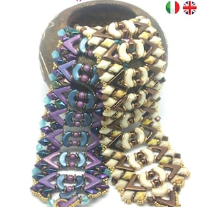 May include: A close-up of a beaded bracelet featuring a purple, blue and brown colour scheme. The bracelet is crafted with small, intricate beads and has a gold-coloured clasp. The bracelet is resting on a brown surface and has a gold-coloured charm with clear crystals. The text "Carnival" is written in purple below the bracelet.