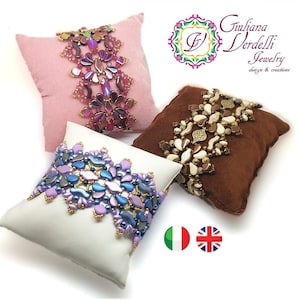 Peut inclure: Trois bracelets en perles présentés sur de petits coussins. Les bracelets sont faits de perles de différentes couleurs, notamment du violet, du bleu, de l'or et du blanc. Les bracelets sont présentés sur un fond blanc.