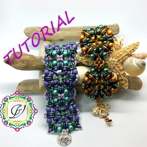 May include: Two beaded bracelets, one in shades of purple, green, and silver, and the other in gold, brown, and green. The bracelets are displayed on a piece of driftwood with seashells and a starfish.