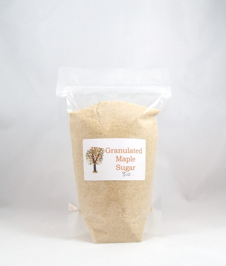 Pu&ograve; includere: Un sacchetto di plastica trasparente pieno di zucchero d'acero granulare. Il sacchetto ha un'etichetta che recita "Granulated Maple Sugar 8 oz."