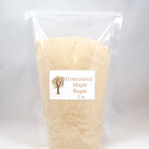 Pu&ograve; includere: Un sacchetto di plastica trasparente pieno di zucchero d'acero granulare. Il sacchetto ha un'etichetta che recita "Granulated Maple Sugar 1 lb."