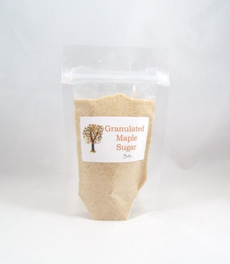 Pu&ograve; includere: Un sacchetto di plastica trasparente pieno di zucchero d'acero granulare. Il sacchetto ha un'etichetta che recita "Granulated Maple Sugar 3 oz."