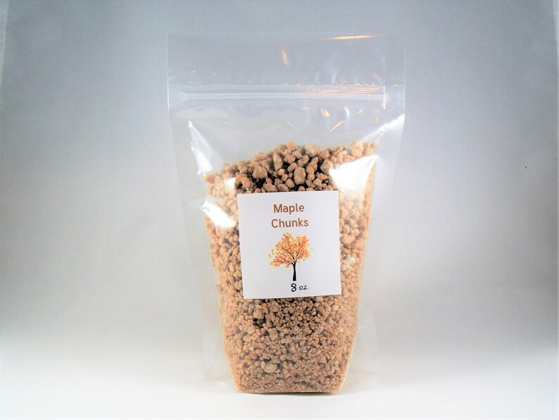 Pu&ograve; includere: Un sacchetto di plastica trasparente pieno di pezzi di acero. Il sacchetto ha un'etichetta che dice "Maple Chunks" con una piccola illustrazione di un albero di acero e "8 oz" stampato su di essa.