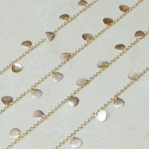 May include: Gold chain necklace with multiple rows of small, dangling, shell-shaped charms.