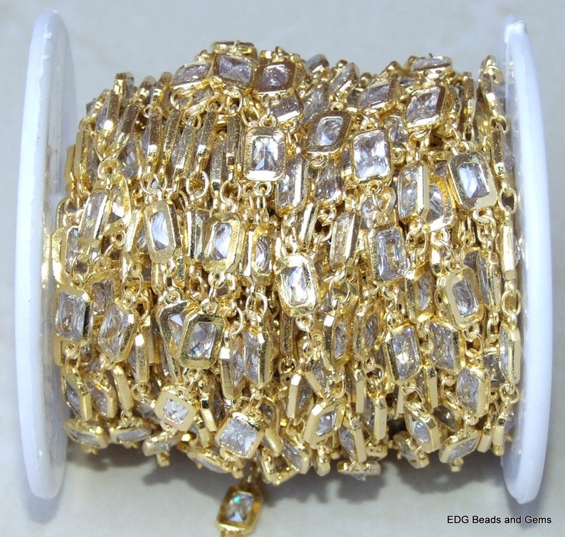 Op de afbeelding: Een spoel met gouden ketting met heldere vierkante kristallen. De ketting is perfect voor het maken van sieraden en knutselen.