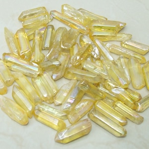 May include: A collection of iridescent yellow quartz points, also known as angel aura quartz, with a variety of sizes and shapes.